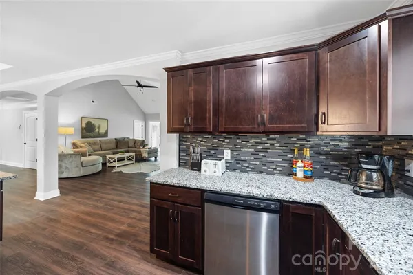 a kitchen with stainless steel appliances granite countertop wooden cabinets a sink and dishwasher