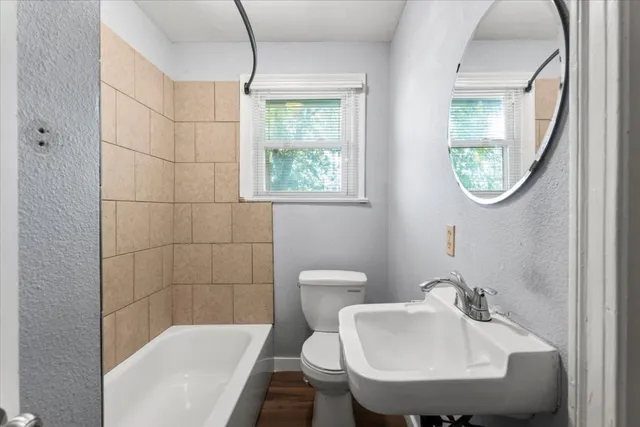 a bathroom with a sink a toilet and a mirror