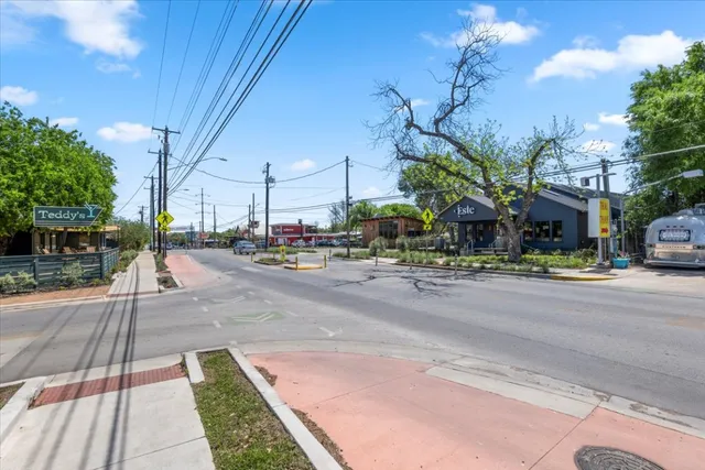 a city street lined with buildings and cars parked on road