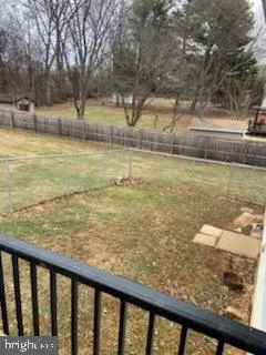 a view of a yard with wooden fence