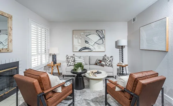 a living room with furniture a couch and two windows