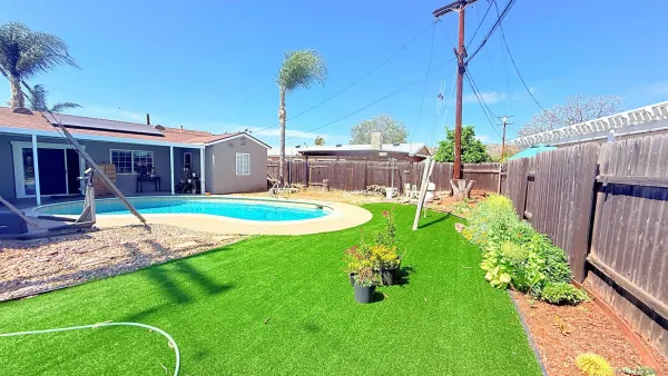 a view of a house with backyard and a swimming pool