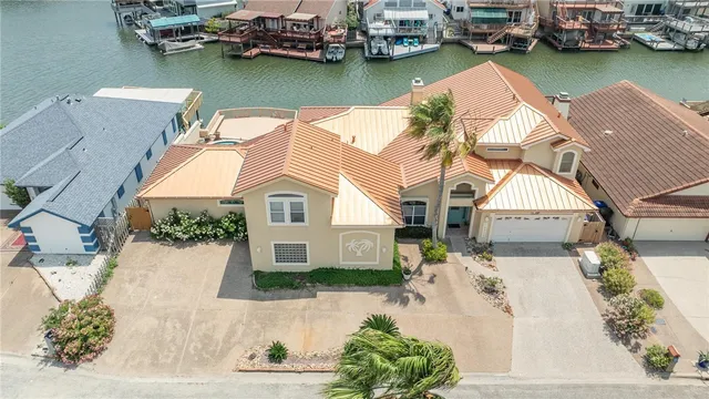 an aerial view of a house with swimming pool and large trees