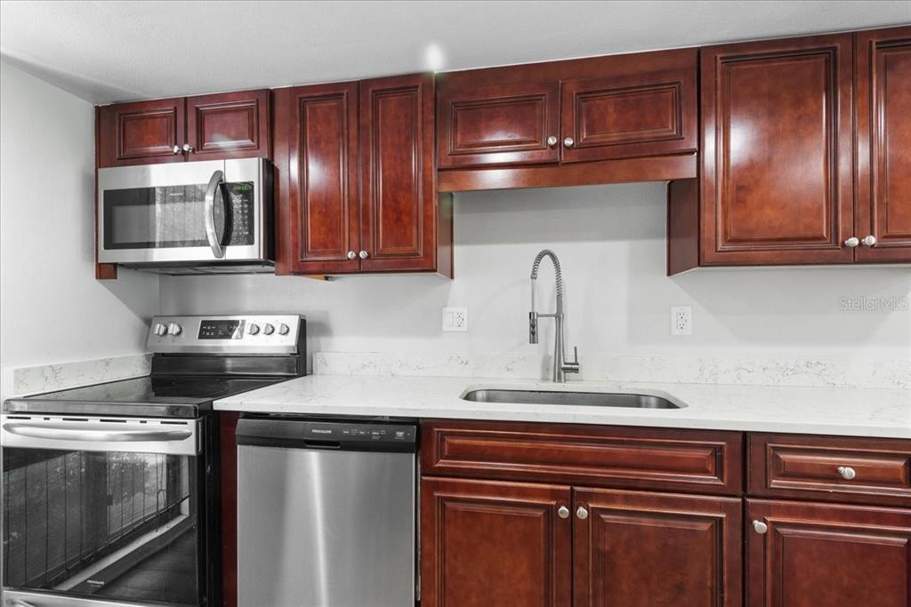 30 Moree Loop, Unit 39 Winter Springs, FL 32708 - Photo 3 of 32 a kitchen with granite countertop stainless steel appliances and wooden cabinets