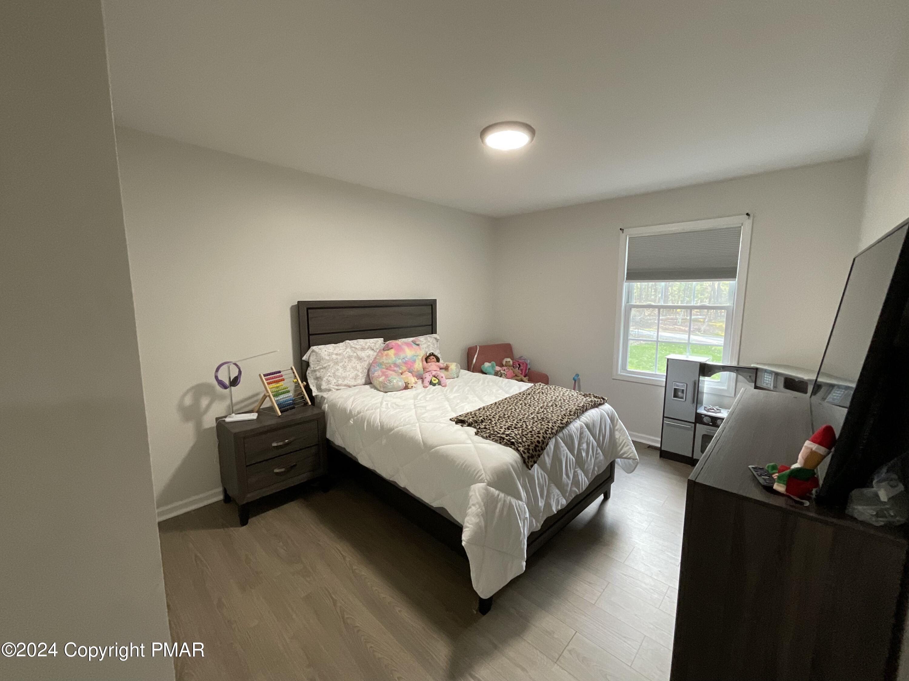 146 Hound Road Dingmans Ferry, PA 18328 - Photo 39 of 50 a bedroom with a bed and wooden floor