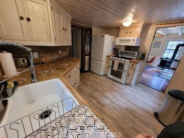 a kitchen with granite countertop a stove top oven a sink a counter space and cabinets