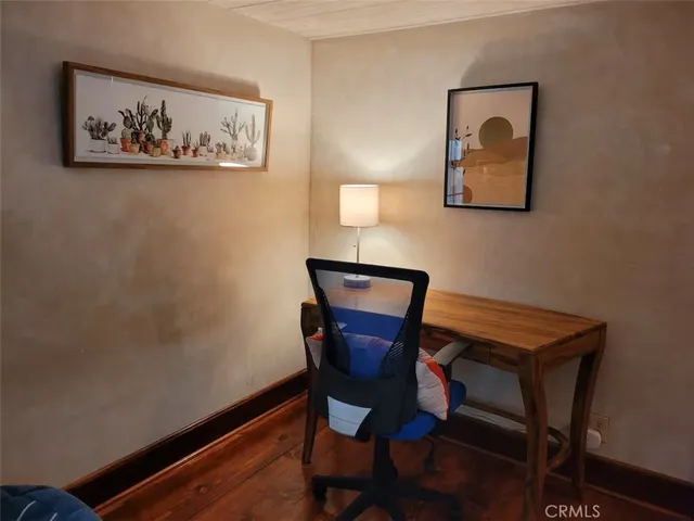 a view of a workspace with furniture and wooden floor