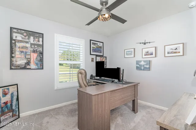 a view of a workspace with furniture and a window
