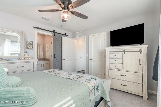 a spacious bedroom with a bed and a flat screen tv