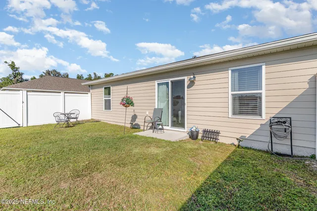 a backyard of a house with table and chairs