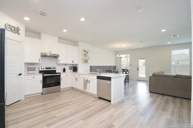 a kitchen with a refrigerator and a stove top oven