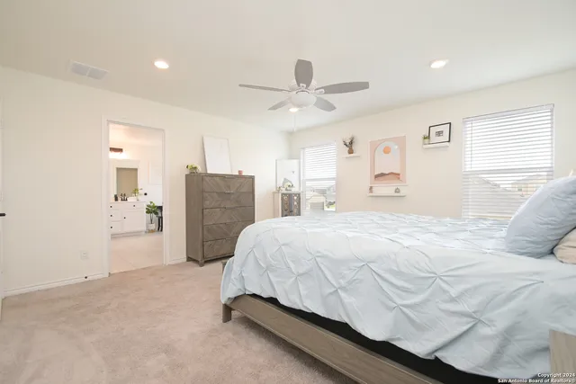 a bedroom with a bed and ceiling fan