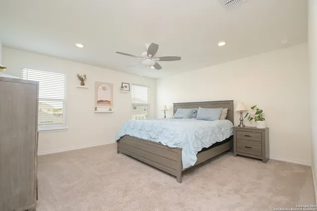 a spacious bedroom with a bed and a ceiling fan