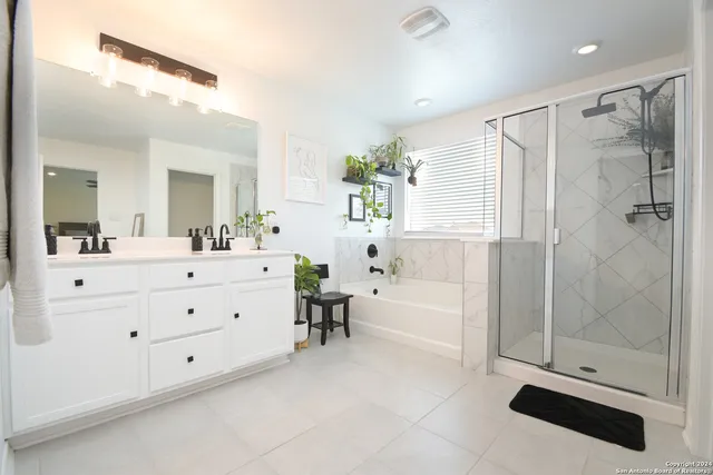 a bathroom with a double vanity sink mirror bathtub and shower
