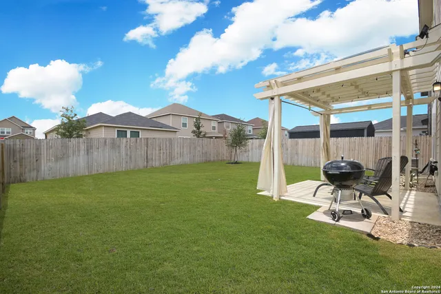 a view of a patio with table and chairs with wooden floor and fence