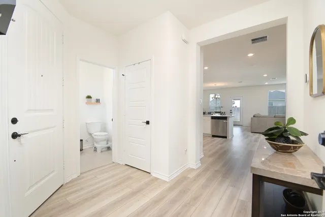a view of a hallway with wooden floor and furniture