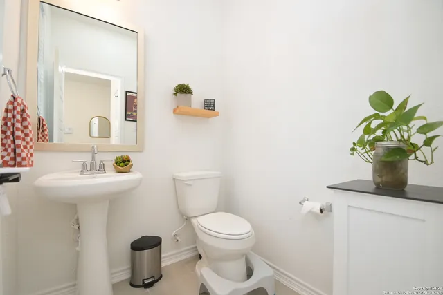a bathroom with a toilet sink and mirror