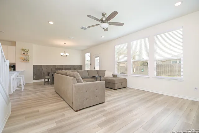a living room with furniture and a large window with wooden floor