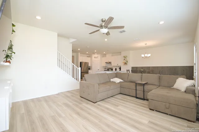a living room with furniture and a ceiling fan