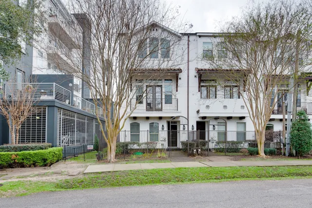 a front view of a residential apartment building with yard and green space