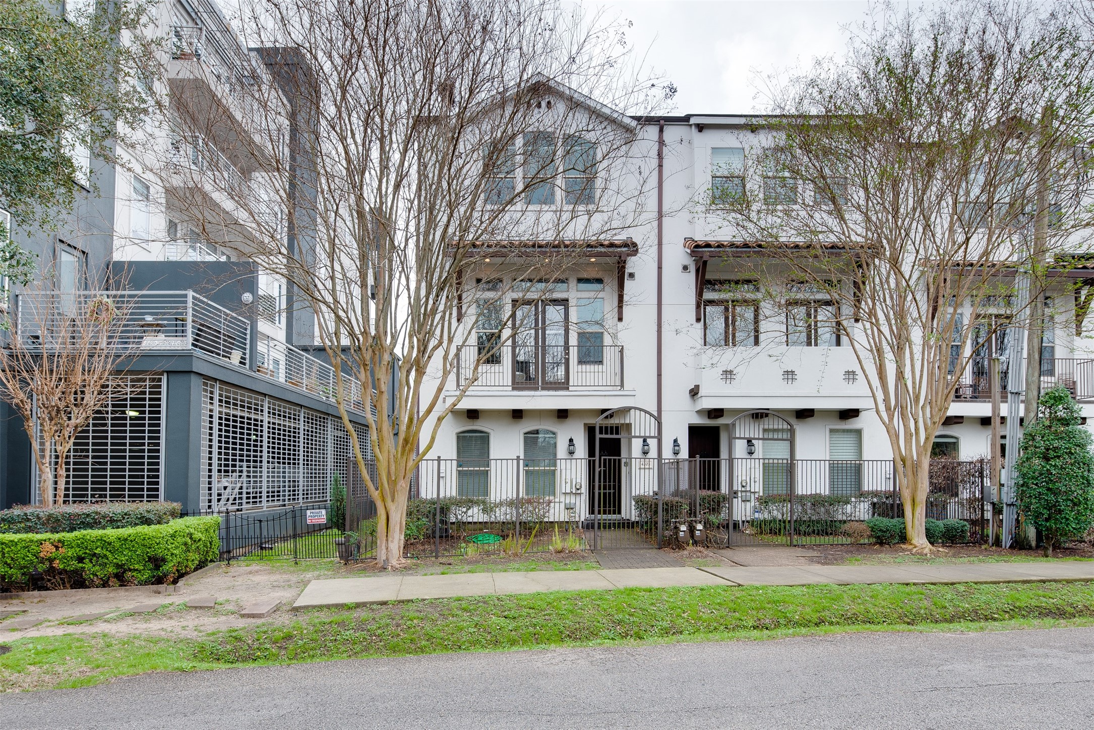 a front view of a residential apartment building with yard and green space