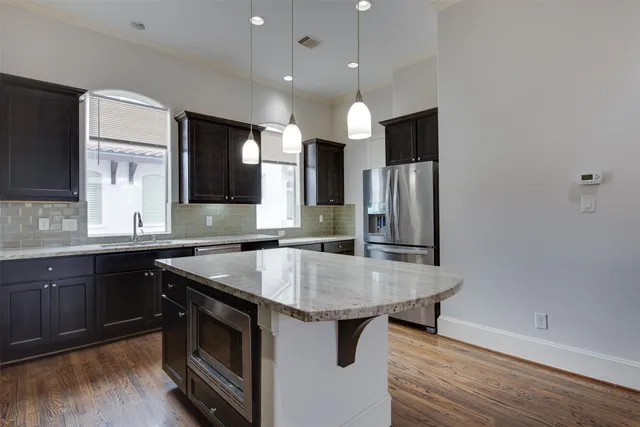 a kitchen with stainless steel appliances granite countertop a sink a stove and a refrigerator