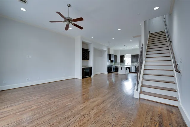 a view of a livingroom with wooden floor and a ceiling fan
