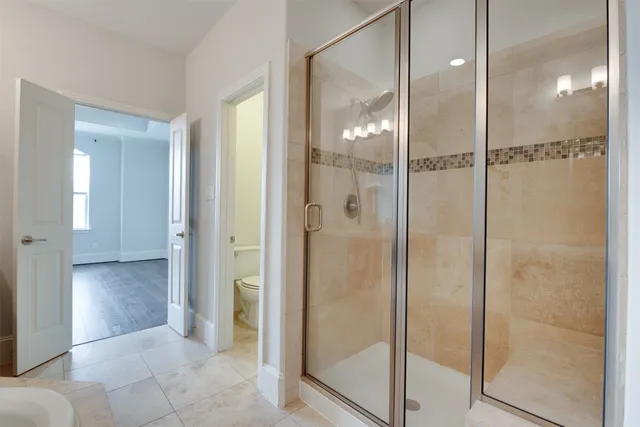 a bathroom with a glass shower door and a mirror