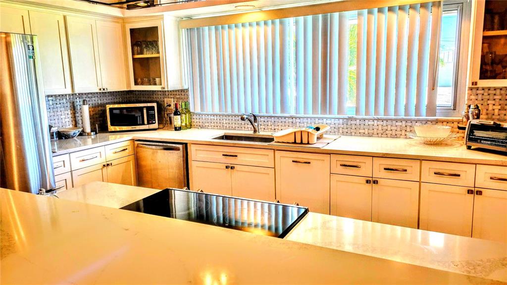 3236 South Lockwood Ridge Road Sarasota, FL 34239 - Photo 16 of 32 a kitchen with stainless steel appliances kitchen island granite countertop a sink and a white cabinets