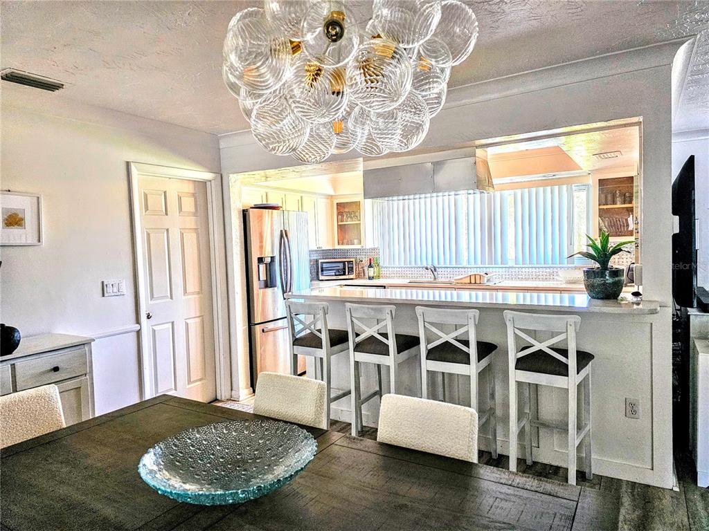 3236 South Lockwood Ridge Road Sarasota, FL 34239 - Photo 17 of 32 a kitchen with a dining table chairs and stove