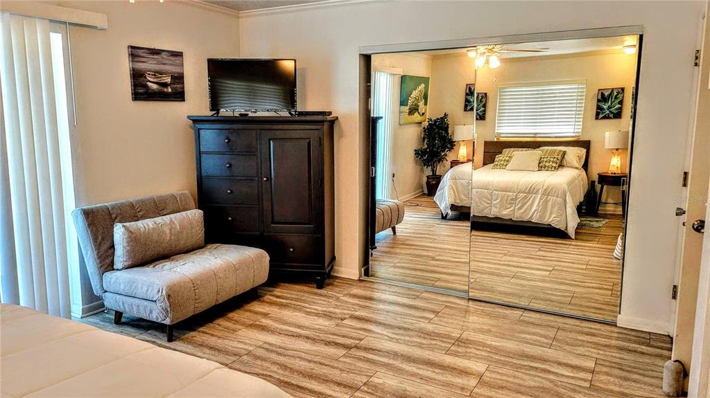 3236 South Lockwood Ridge Road Sarasota, FL 34239 - Photo 23 of 32 a bedroom with furniture and a flat screen tv