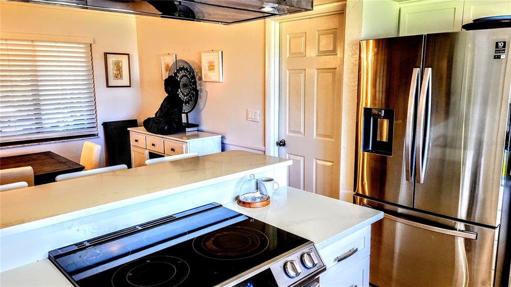 3236 South Lockwood Ridge Road Sarasota, FL 34239 - Photo 8 of 32 a kitchen with stainless steel appliances a refrigerator and a stove top oven