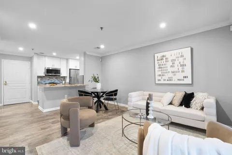 a living room with furniture and kitchen view