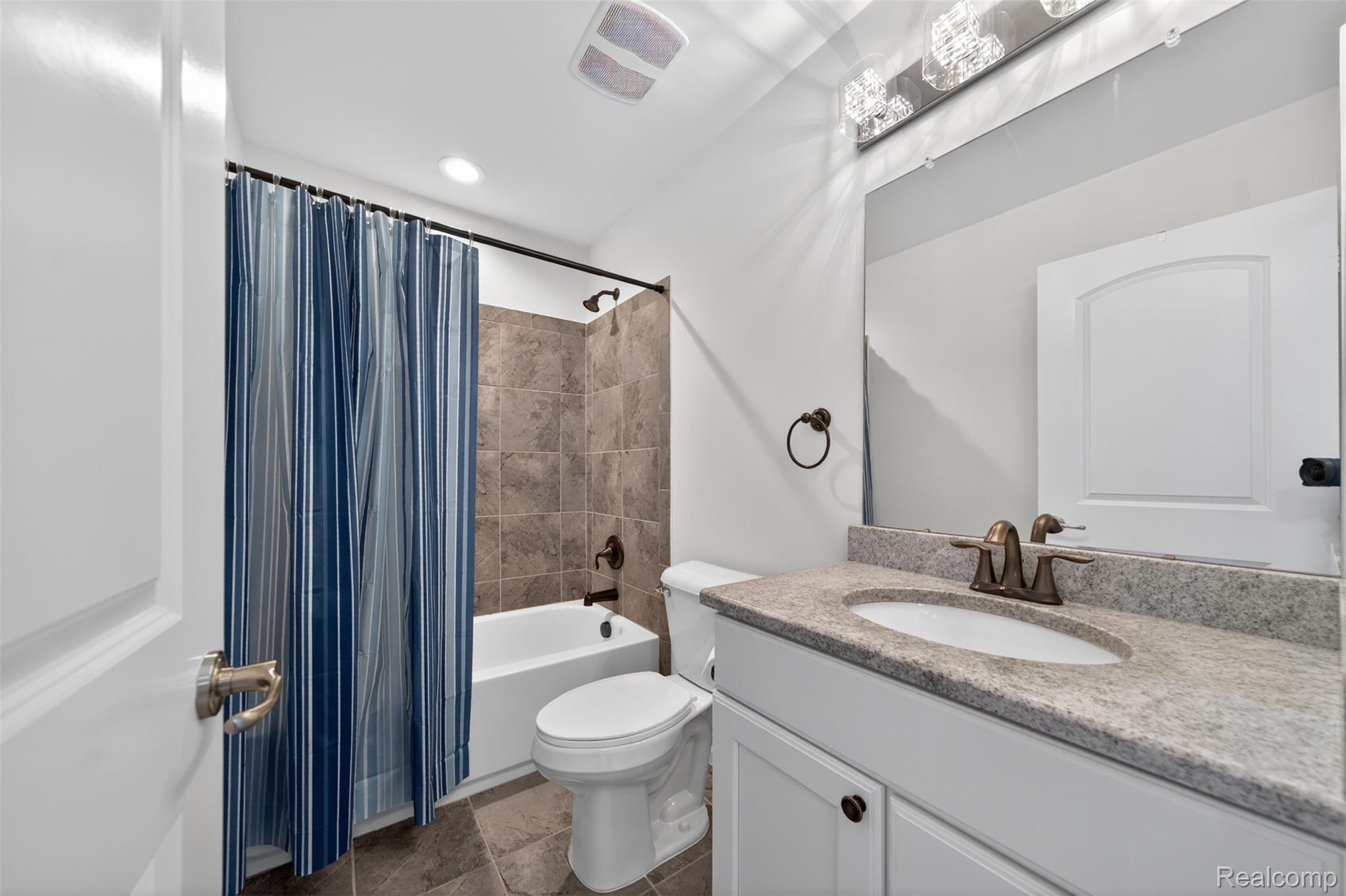 3534 South Rochester Road Royal Oak, MI 48073 - Photo 20 of 25 Bathroom featuring a white vanity with a stone-finish countertop, undermount sink, and bronze-finish faucet