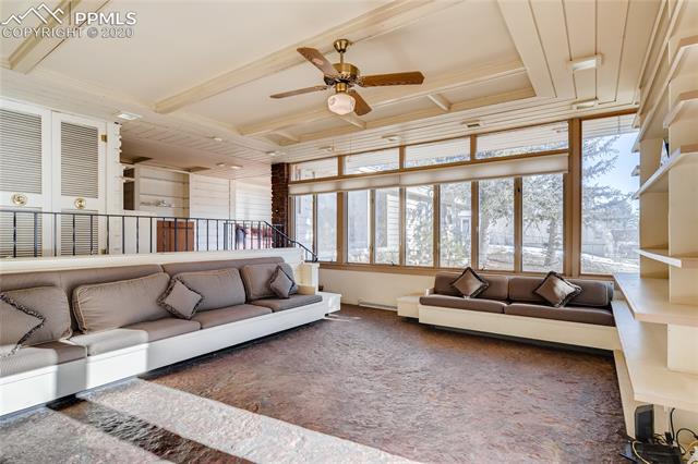 7720 Marriott Road Cascade, CO 80809 - Photo 11 of 28 Typical Mid-Century Modern living room with floor to ceiling windows and built in bookshelves and couches