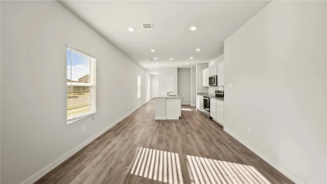 a view of a living room with wooden floor and a window