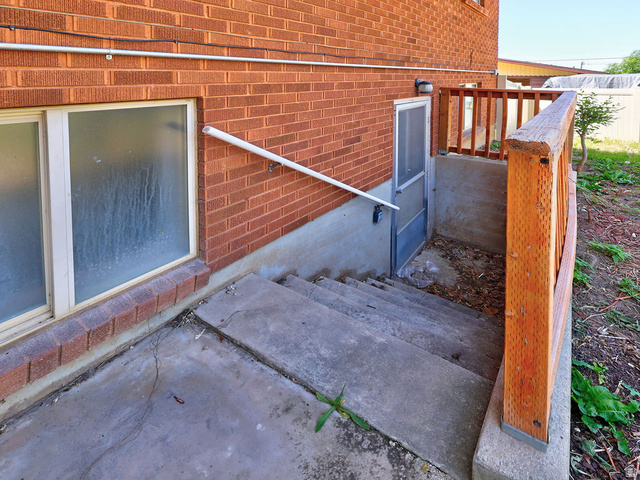 1272 Cook Street Ogden, UT 84404 - Photo 5 of 46 Brick exterior with concrete stairs to a lower-level entry