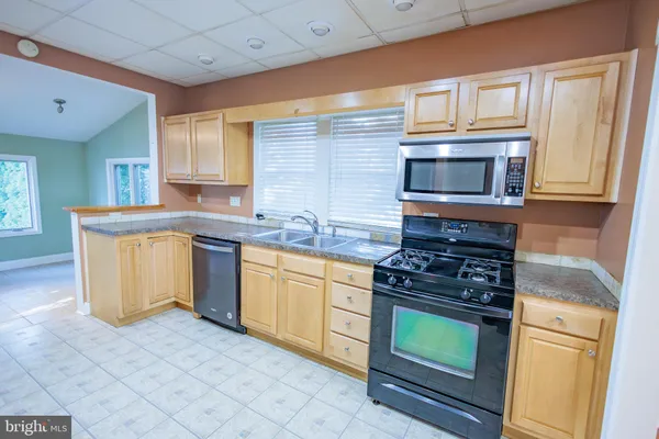 a kitchen with stainless steel appliances kitchen island granite countertop a refrigerator and a stove