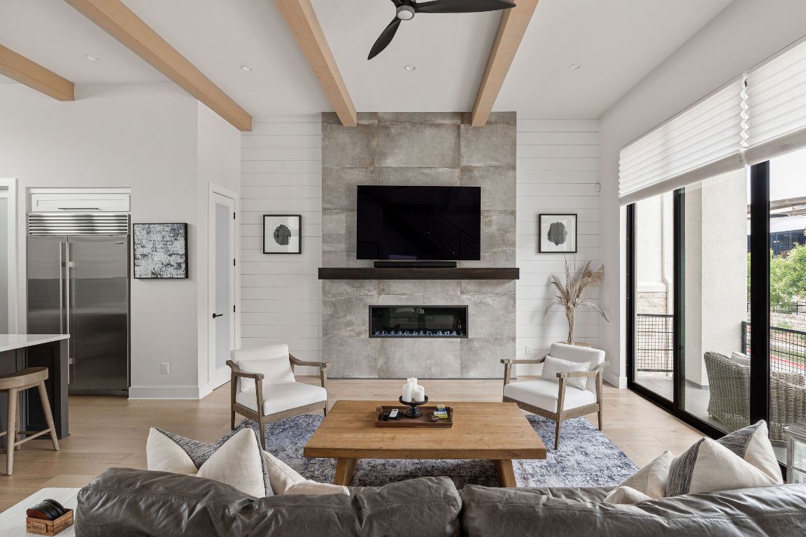 a living room with furniture a flat screen tv and a fireplace