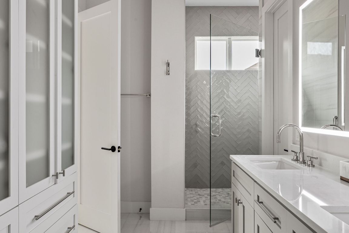 13410 Galleria Circle Austin, TX 78738 - Photo 9 of 28 a bathroom with a granite countertop sink a mirror and shower