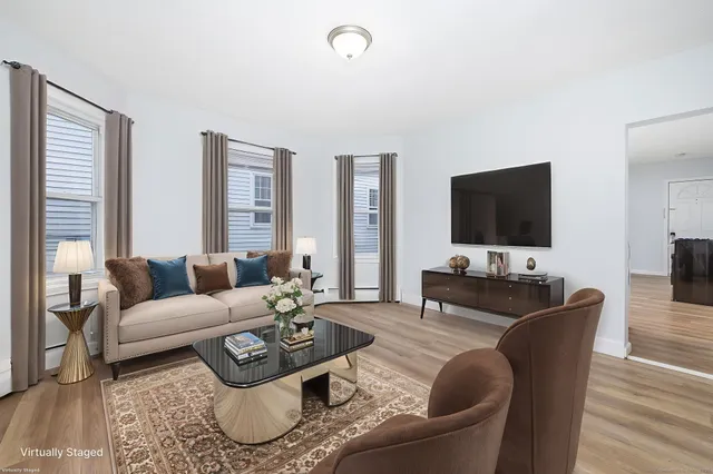 a living room with furniture a flat screen tv and a large window