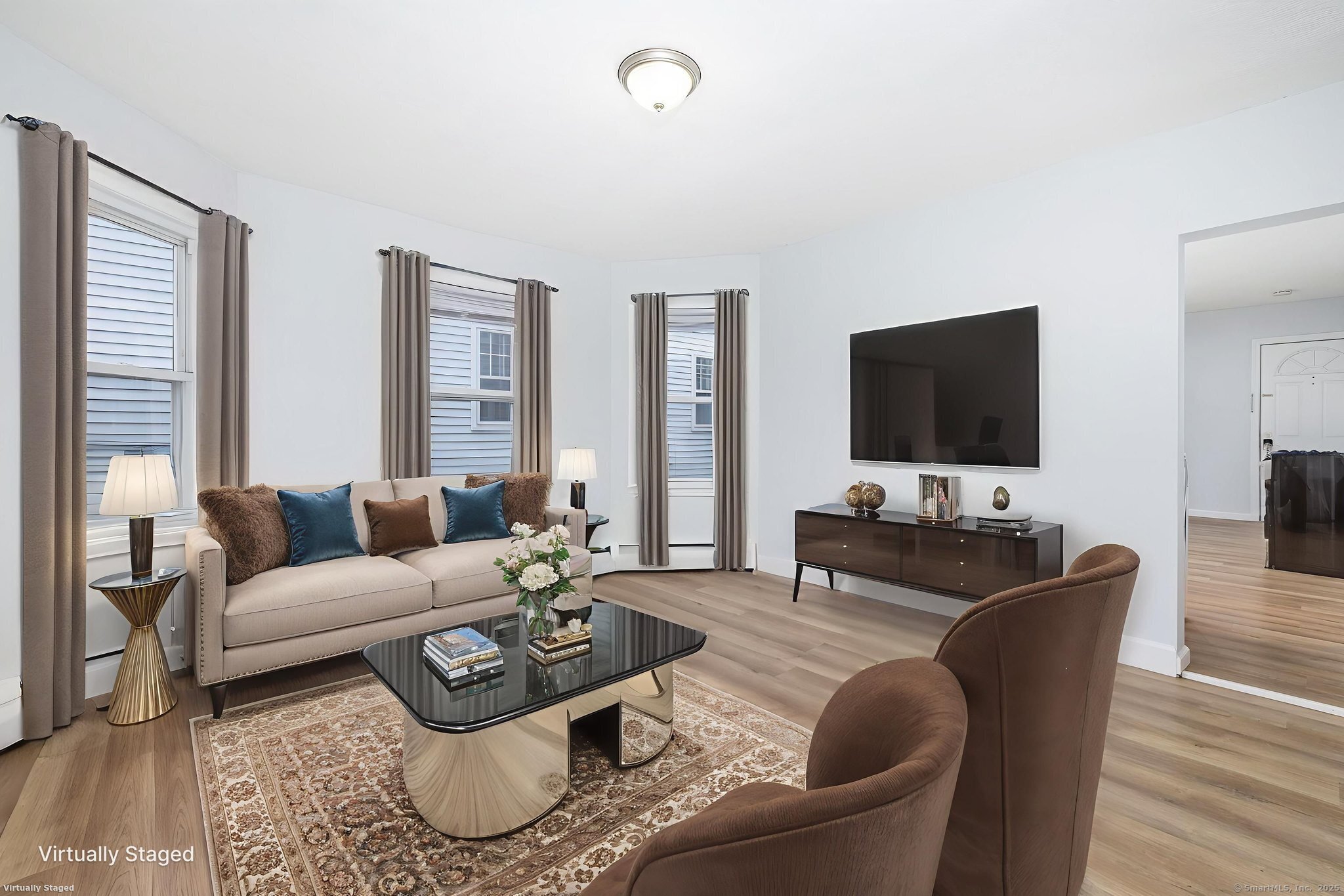 a living room with furniture a flat screen tv and a large window