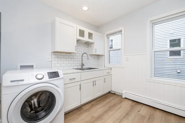 a view of a kitchen with sink washer and dryer