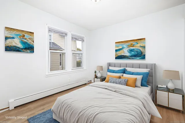 a bedroom with bed and wall painting with wooden floor