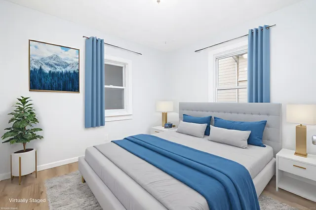 a bedroom with a large bed and a potted plant