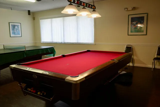 a room with pool table and windows