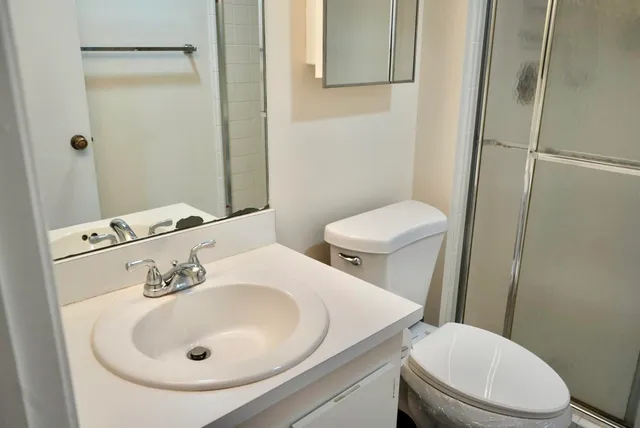 a view of a hallway with closet and a bathroom