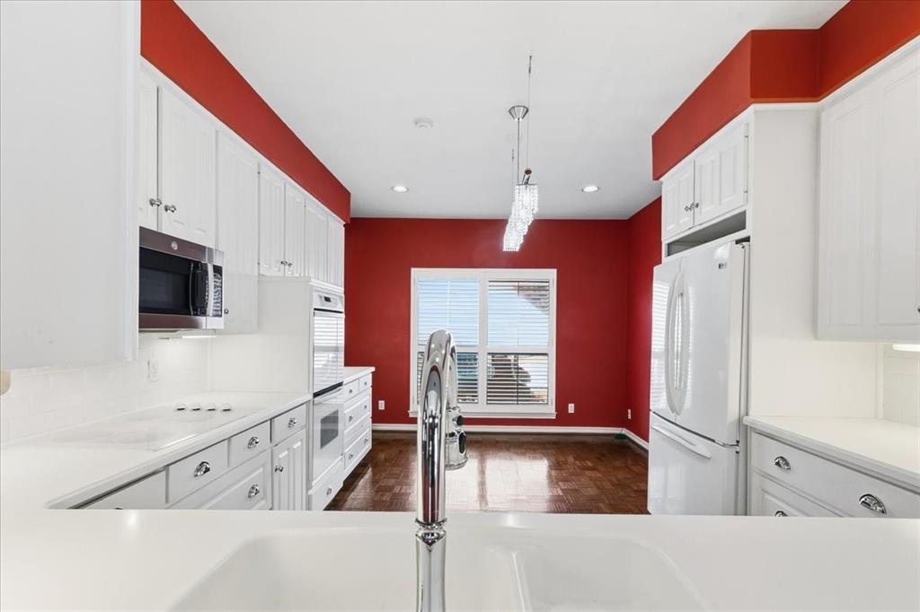 22 1 Main Place Benbrook, TX 76126 - Photo 21 of 40 a kitchen with stainless steel appliances granite countertop a refrigerator a oven a sink and white cabinets with wooden floor