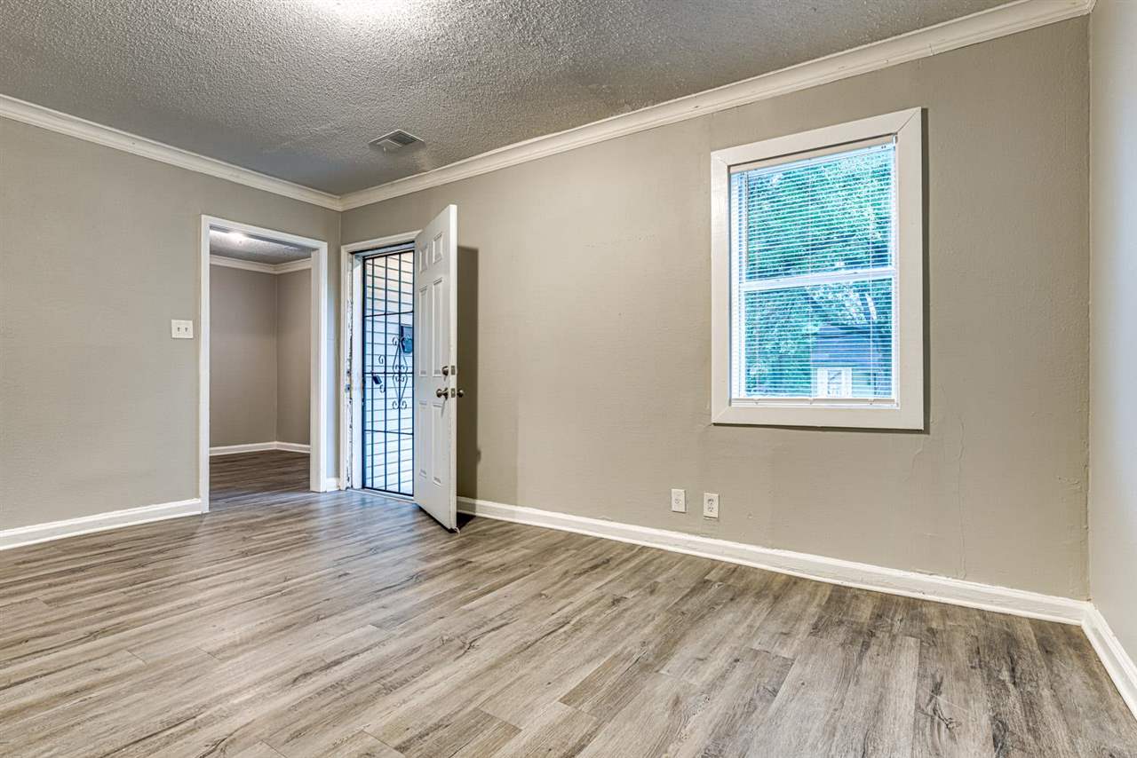 1023 Parkland Road Memphis, TN 38111 - Photo 13 of 22 an empty room with wooden floor and windows