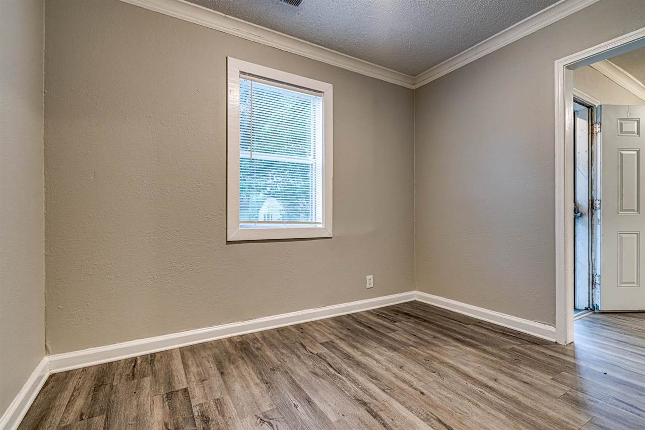 1023 Parkland Road Memphis, TN 38111 - Photo 16 of 22 an empty room with wooden floor and windows